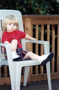 Photo of a young child sitting on a chair for a time out
